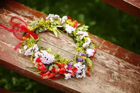 Kolorowy wianek z kwiatów leżący na drewnianej ławce