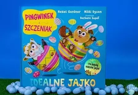 Okładka książki pod tytułem "Idealne jajko" przedstawiająca głównych bohaterów pingwinka i szczeniaczka znajdujacych się w kolorowych pisankach.
